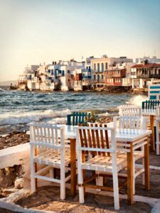 Tables and chairs of a Greek out door restaurant by the ocean 