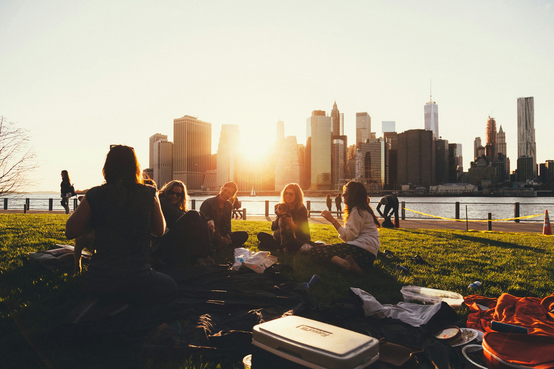 People having a picnic in the city by water and city Skyline view background