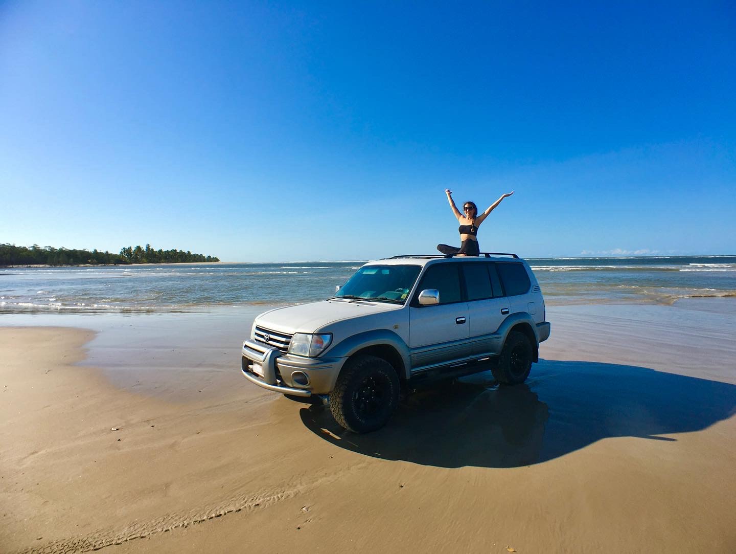 Girl on a car on the beach