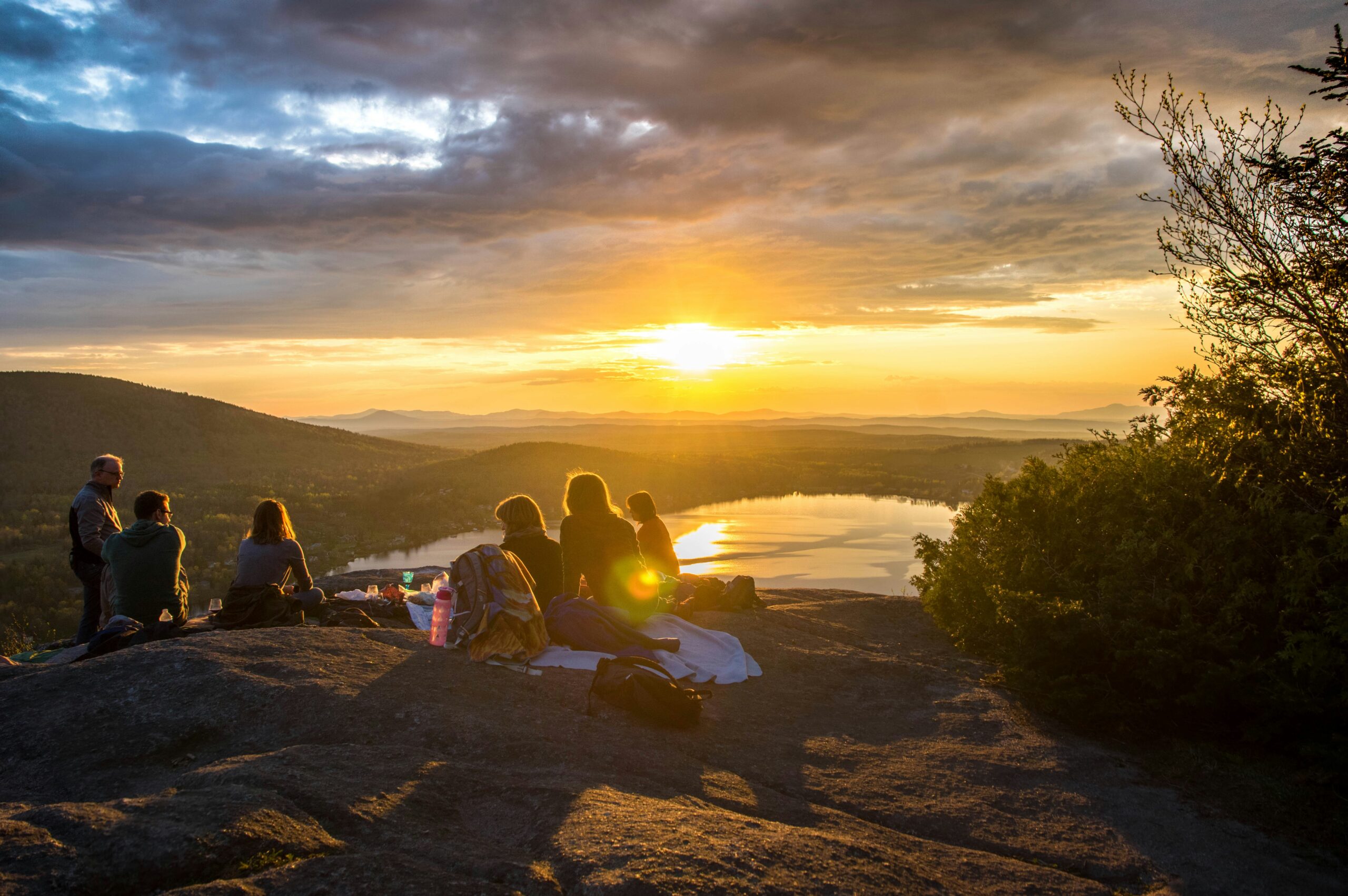 people having a picnic on a mountain top on sunset