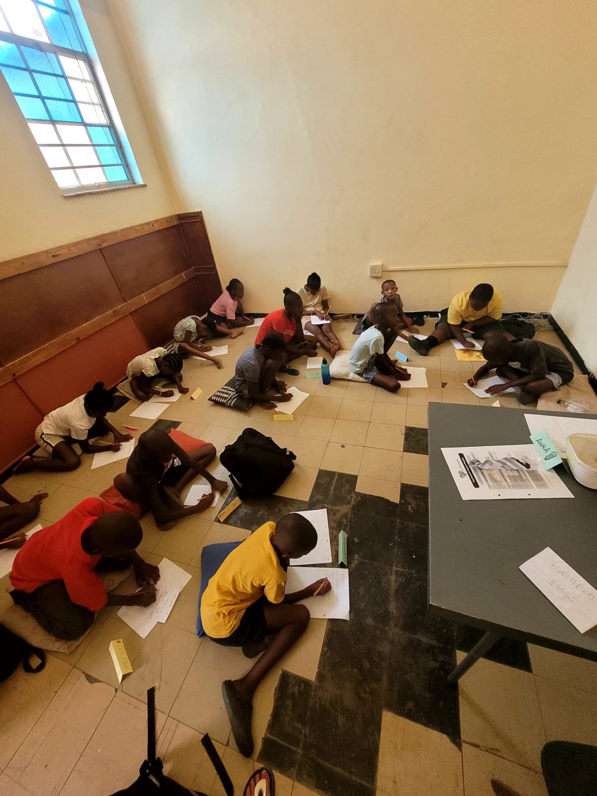 School kids in a room in africa on the floor