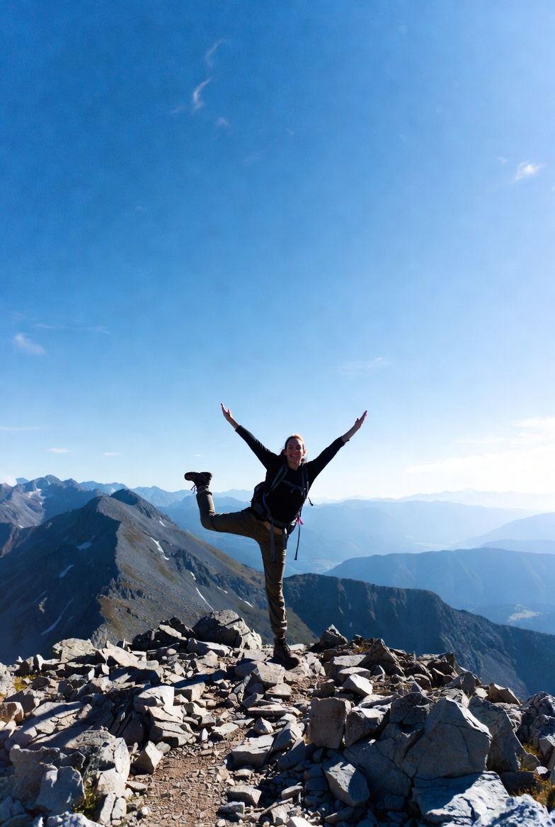 Girl on a mountain doing a fun yoga pose